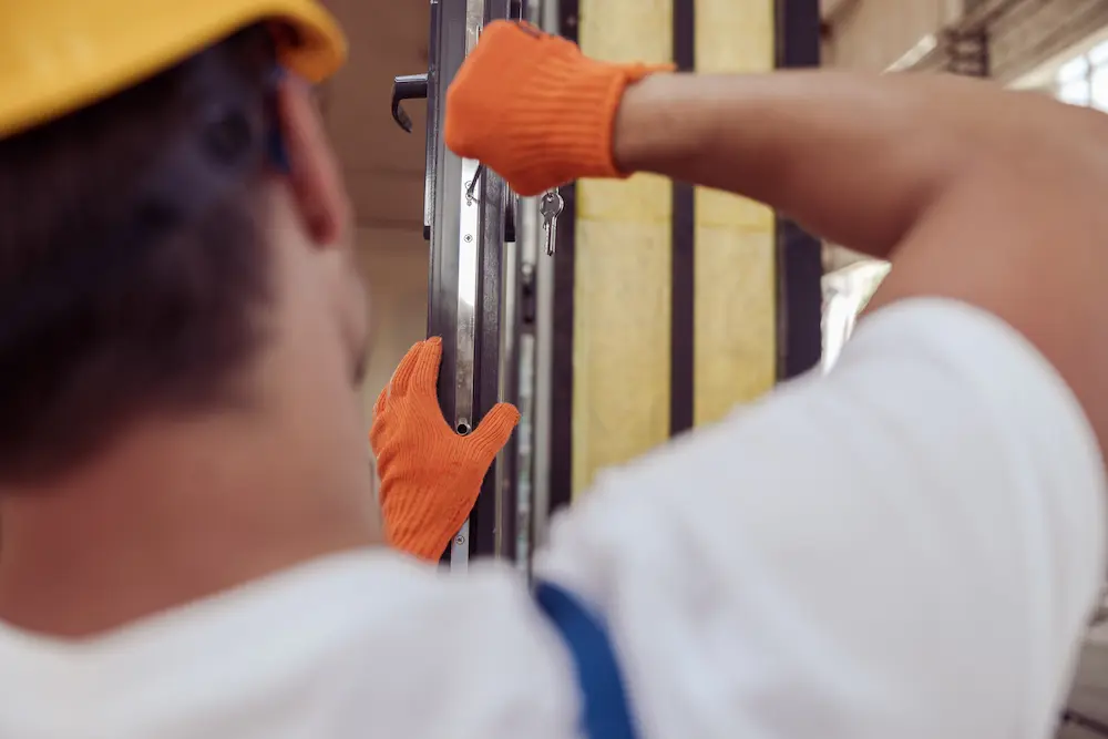 Fabbro al lavoro su una serratura di una porta d'ingresso a Pianoro